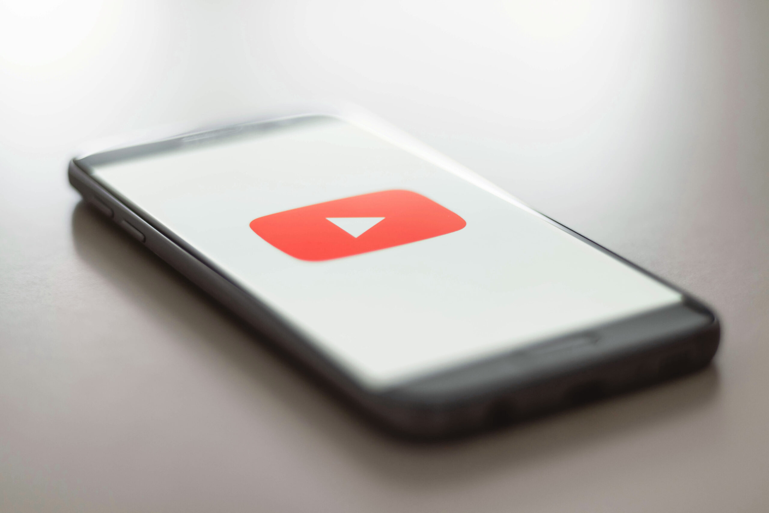 SEO for YouTube, image of a smartphone resting on a surface with the YouTube icon on screen.