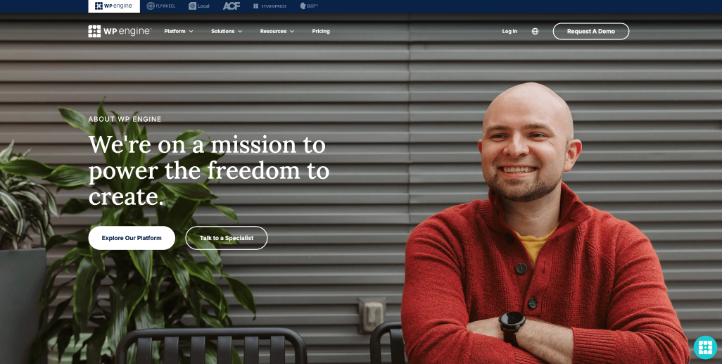 Wix vs WordPress, image of the “About Us” WordPress webpage featuring an image of a smiling man wearing a button down red sweater and yellow undershirt with large copy that reads “ABOUT WP ENGINE, We’re on a mission to power the freedom to create.”