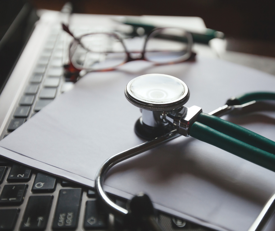 The Future of Local Search in Healthcare, SEO for AI, image of a green and silver stethoscope on a piece of white paper, laid across a computer keyboard.