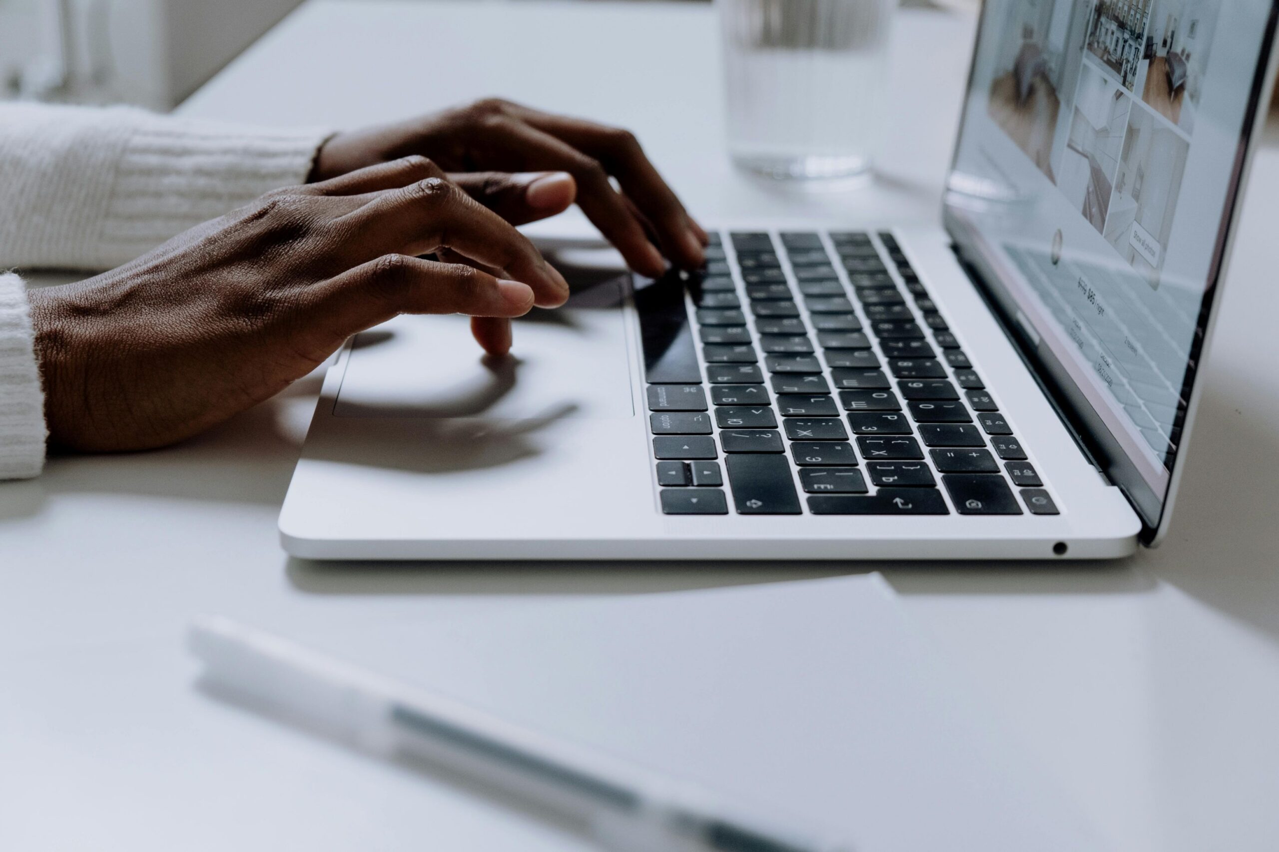 Optimizing your book on Amazon KDP, a close up of hands type on a laptop keyboard with an image gallery on the screen.