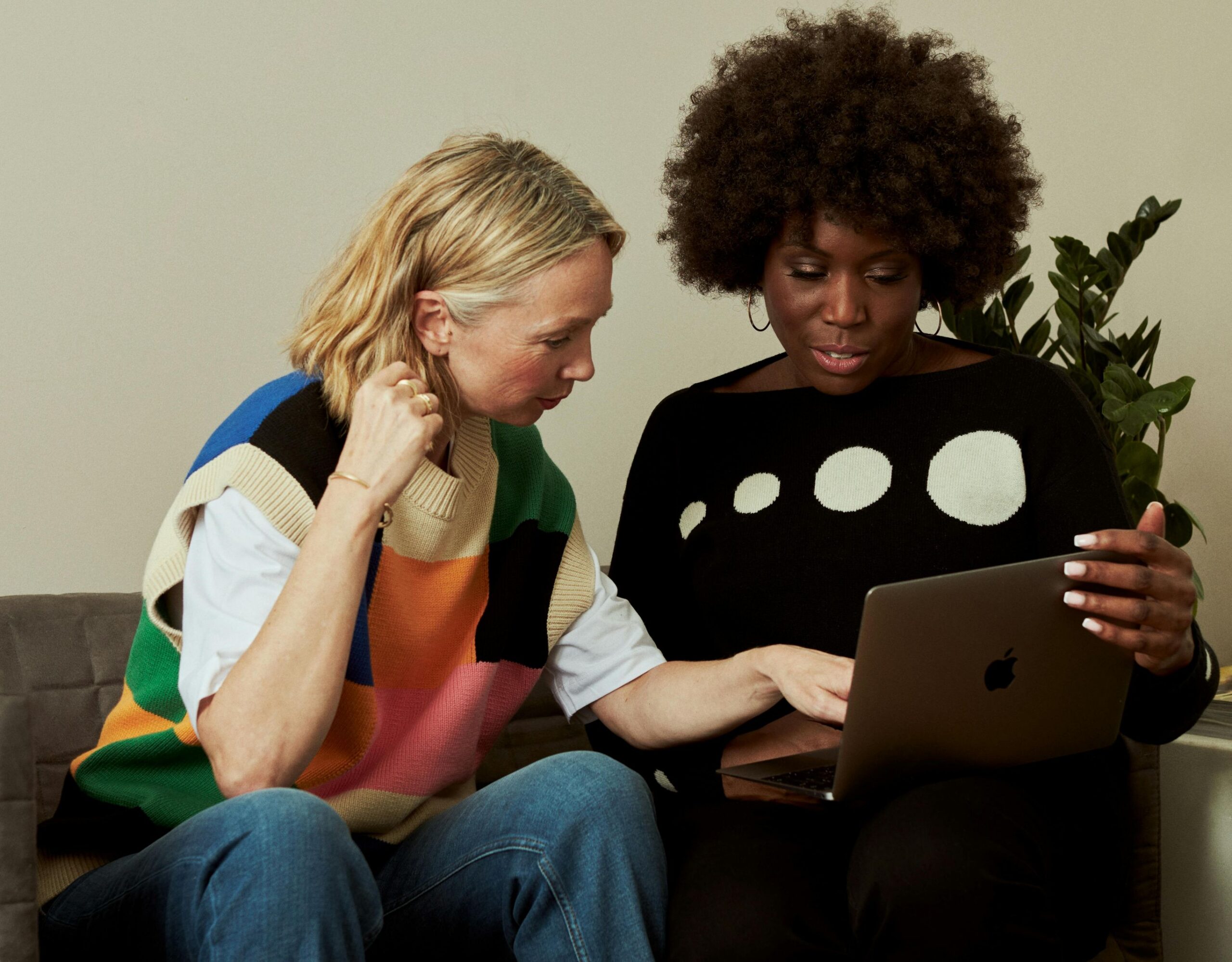 Optimizing your book on Amazon KDP, two women sitting and looking at a laptop together.