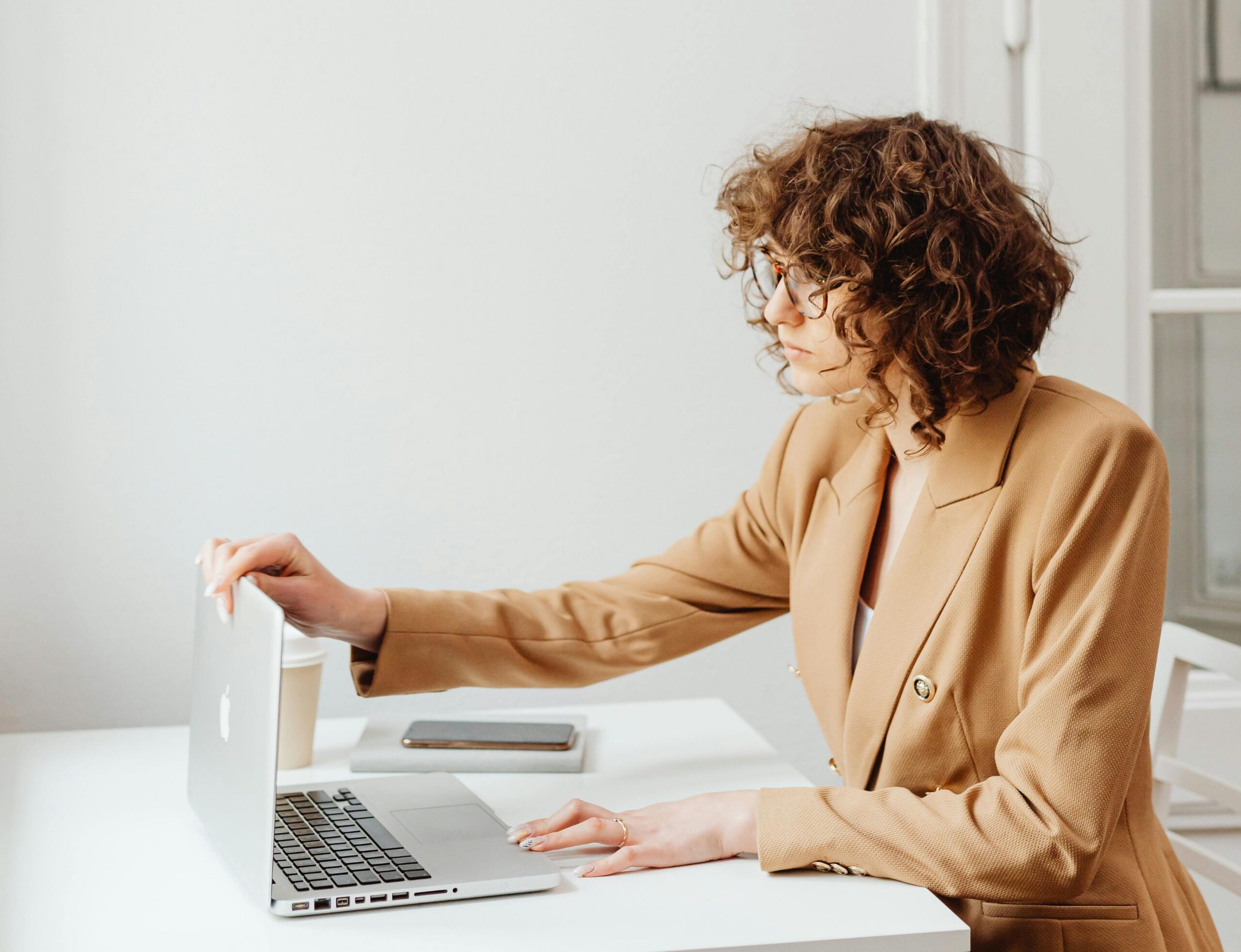 online reputation management, online therapy reviews, image of a woman sitting at a table closing her laptop.