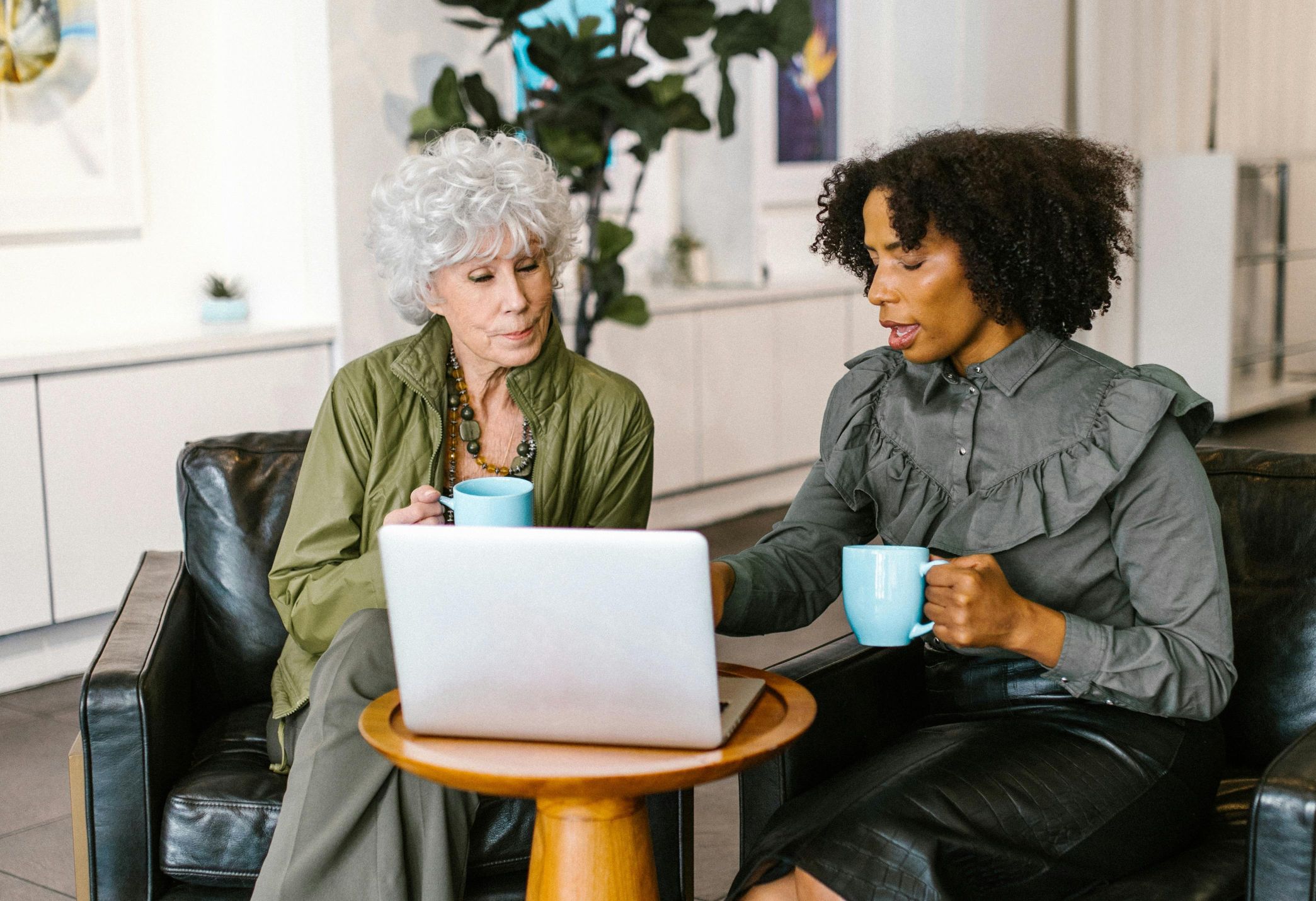 Online therapy reviews, how to ask for a review, how to ask for a google review, image of two women colleagues drinking coffee and looking at a laptop computer.