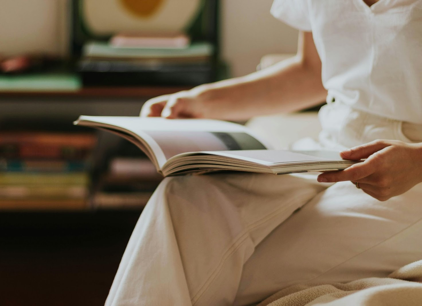best self-publishing platform, image of a woman sitting with an open book in her lap.