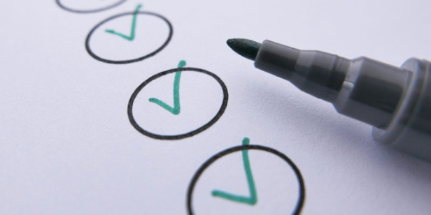 email testing, closeup of a checklist with green checks and a marker.