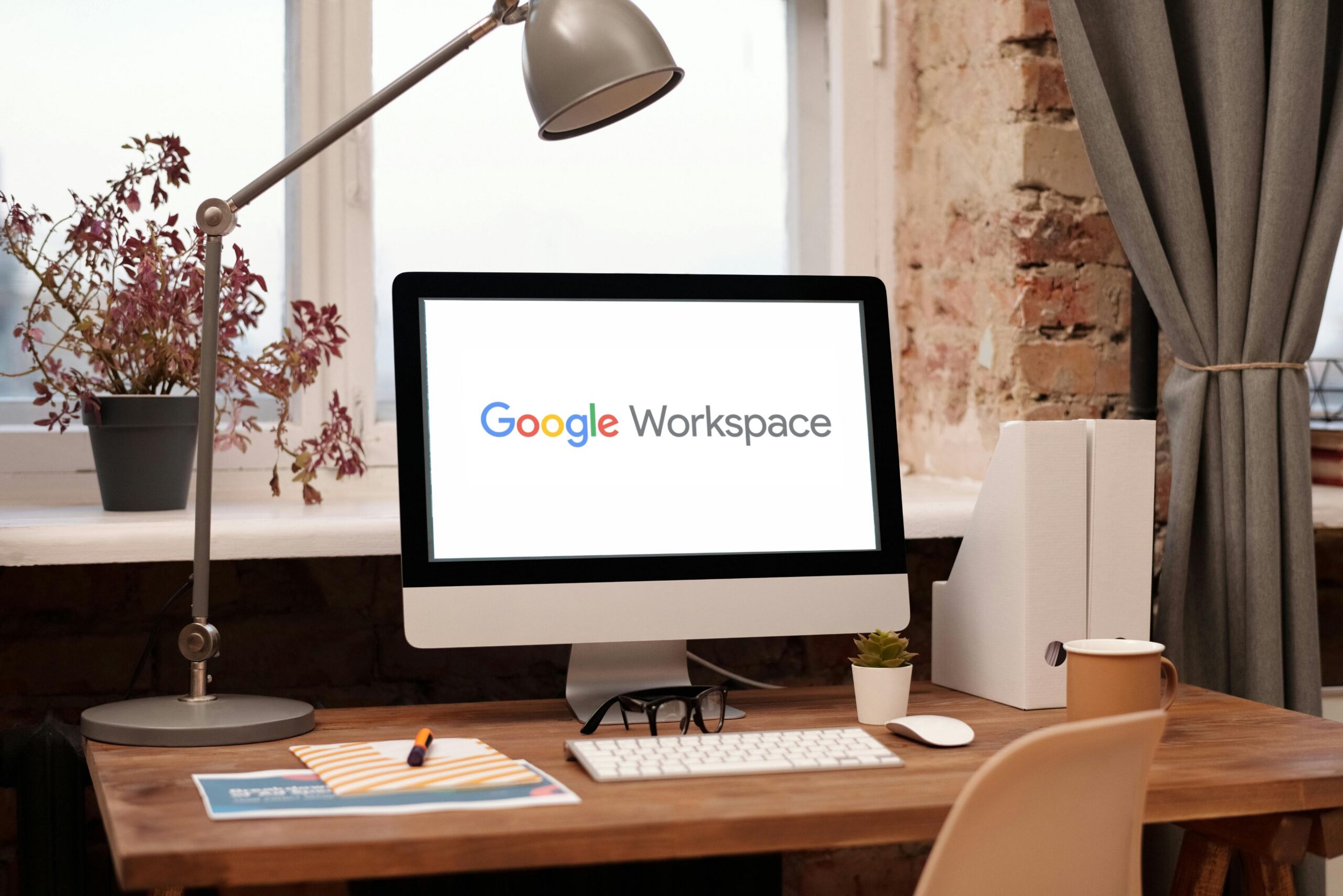 Image of a computer on a desktop with the Google Workspace logo on the screen.