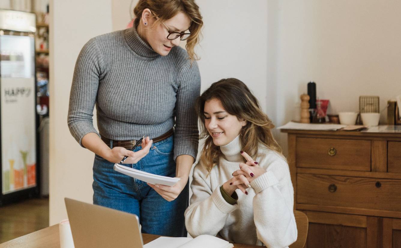 Two wellness professionals in sweaters at a desk creating a lead magnet for their practice