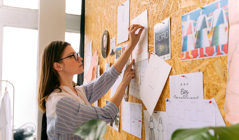 Health professional pins a printed marketing flyer to a community bulletin board.