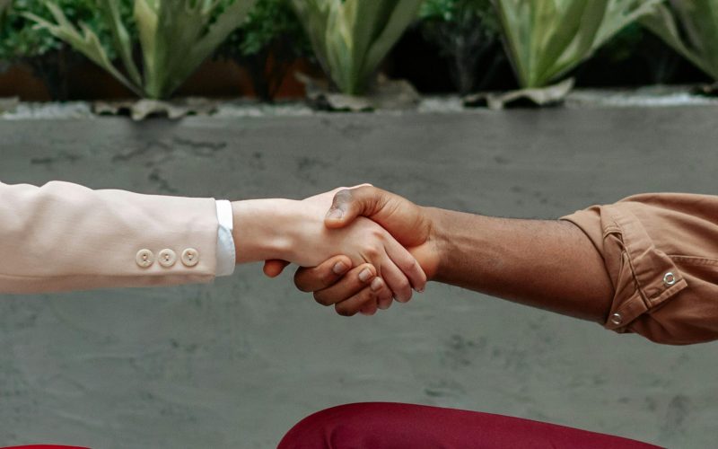 website disclaimer and privacy policy, image of two arms with hands shaking in the middle.